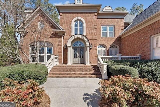 view of exterior entry featuring brick siding and french doors