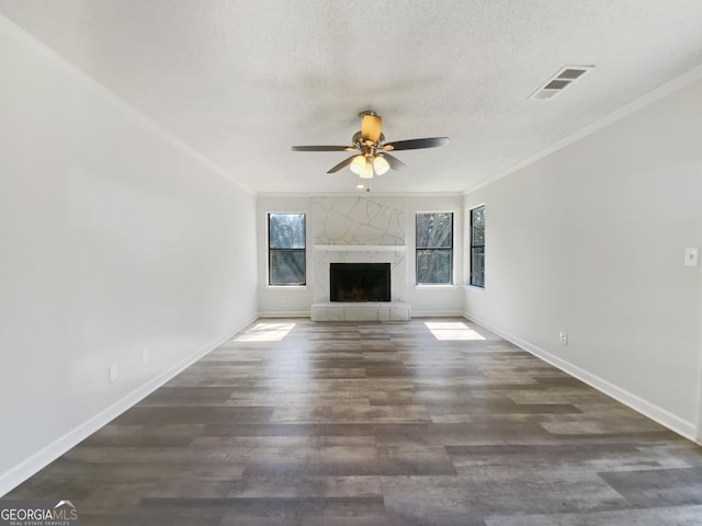 unfurnished living room featuring visible vents, wood finished floors, crown molding, a premium fireplace, and baseboards