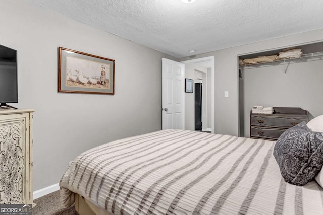 bedroom with a closet, a textured ceiling, and baseboards