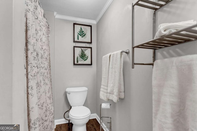 full bathroom featuring a shower with curtain, wood finished floors, baseboards, crown molding, and toilet