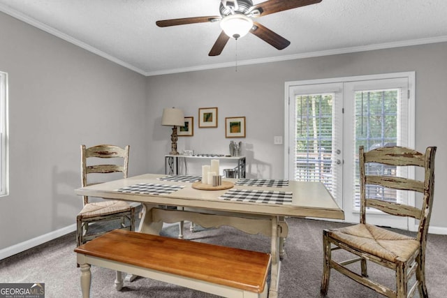 dining area with baseboards, carpet, ornamental molding, and a textured ceiling