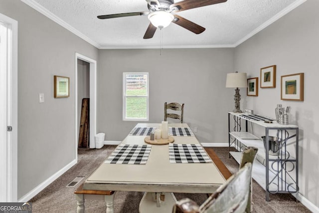 carpeted dining room with a textured ceiling, crown molding, baseboards, and a ceiling fan