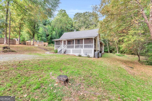 view of front of property featuring a front yard and a sunroom