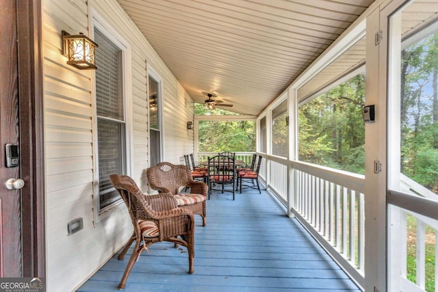 wooden deck featuring a porch and ceiling fan