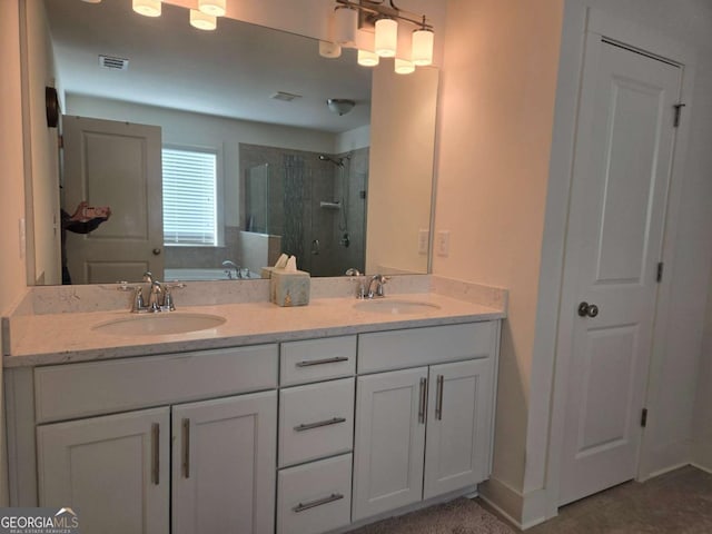 bathroom with a tile shower, visible vents, a bath, and a sink