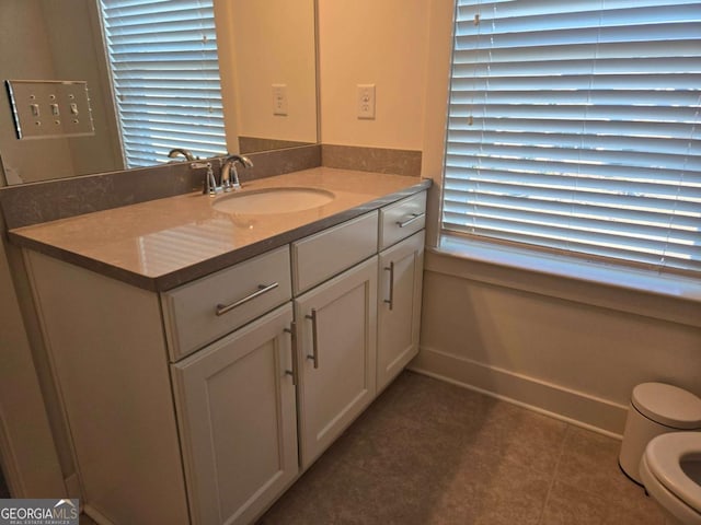 bathroom with tile patterned floors, baseboards, toilet, and vanity