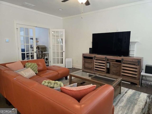 living area with ornamental molding, wood finished floors, french doors, baseboards, and ceiling fan