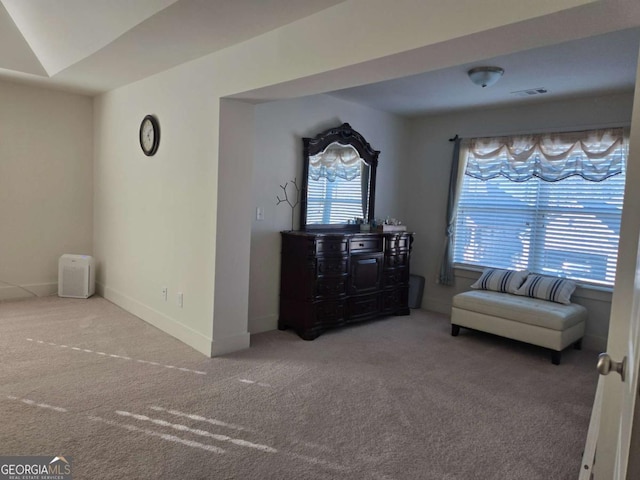 living area with baseboards, visible vents, and carpet floors