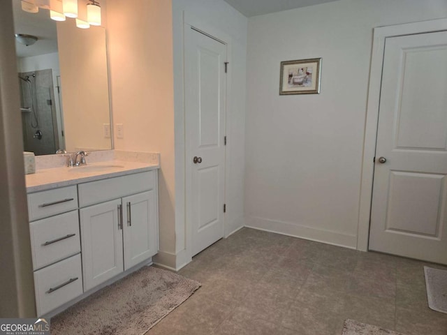 bathroom with baseboards, walk in shower, and vanity