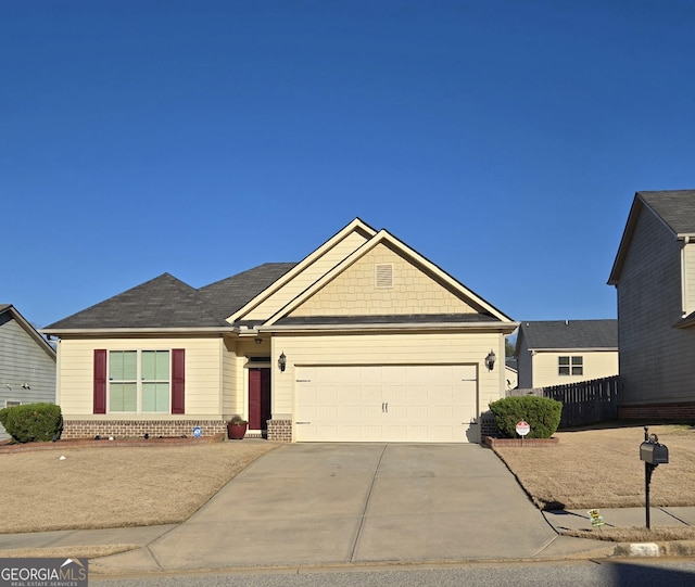 view of front of house with concrete driveway, an attached garage, fence, and brick siding