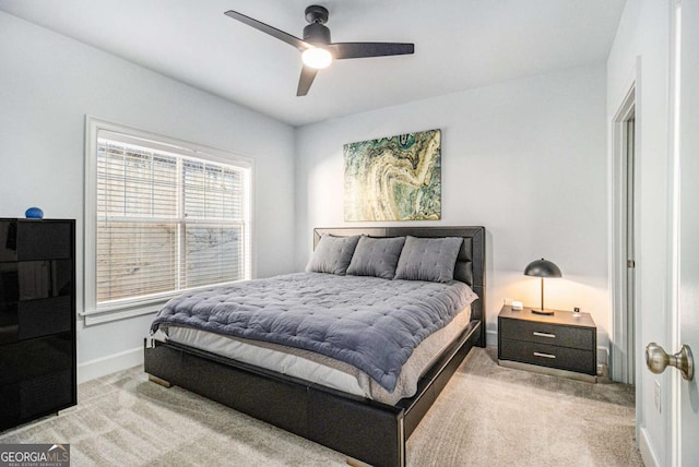 bedroom with light colored carpet, baseboards, and ceiling fan