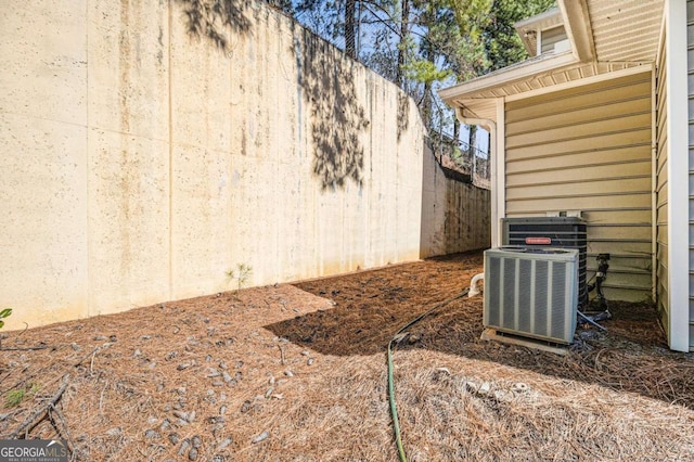 view of yard featuring central air condition unit and fence