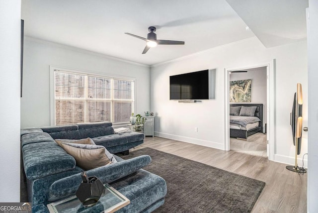 living area featuring ceiling fan, wood finished floors, baseboards, and ornamental molding