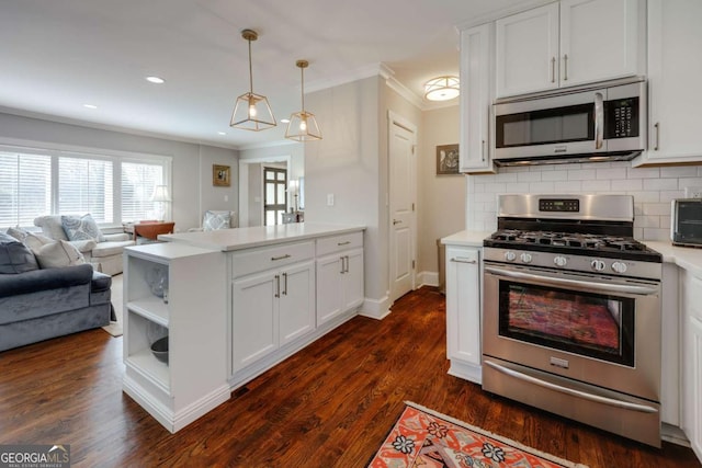 kitchen featuring open floor plan, appliances with stainless steel finishes, a peninsula, light countertops, and decorative backsplash