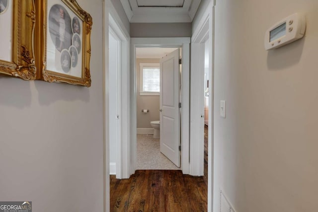 hallway with dark wood finished floors, visible vents, attic access, and baseboards