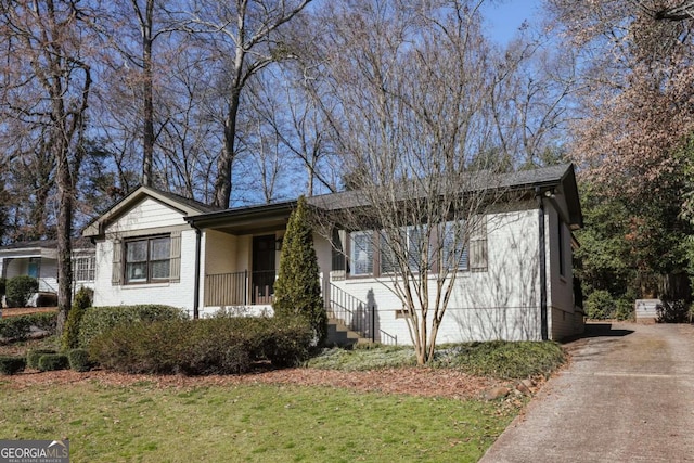 view of front of house featuring brick siding and a front yard