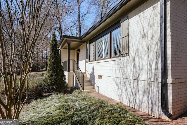 view of home's exterior with crawl space and brick siding