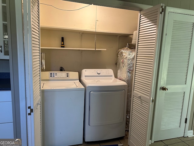 clothes washing area with laundry area, tile patterned floors, and washer and clothes dryer