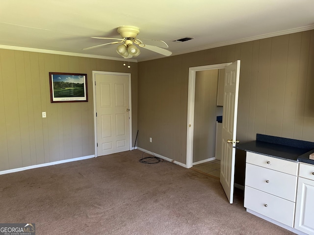 unfurnished bedroom with ornamental molding, baseboards, visible vents, and light carpet