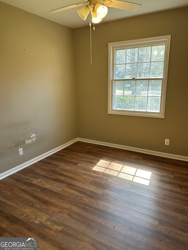 empty room with ceiling fan, baseboards, and dark wood-style flooring