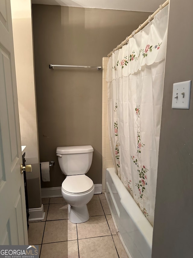 full bathroom featuring tile patterned flooring, toilet, shower / tub combo with curtain, and baseboards