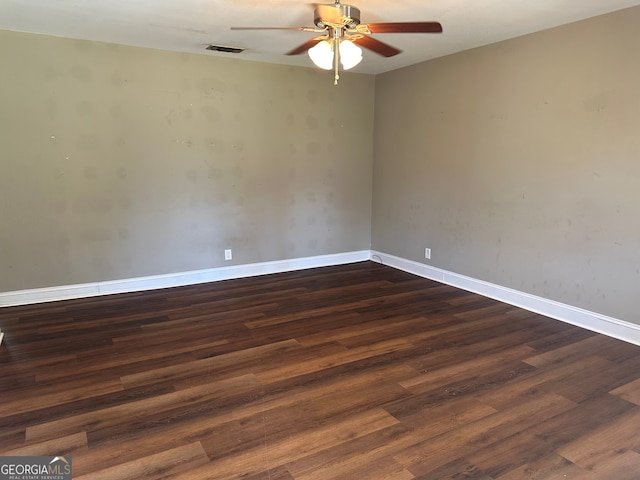 unfurnished room with visible vents, ceiling fan, dark wood-type flooring, and baseboards