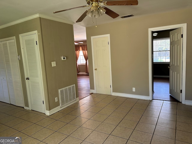 interior space with light tile patterned floors, visible vents, baseboards, and ceiling fan