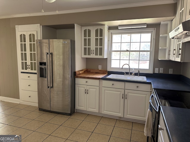 kitchen with a sink, stainless steel fridge, crown molding, and white cabinetry