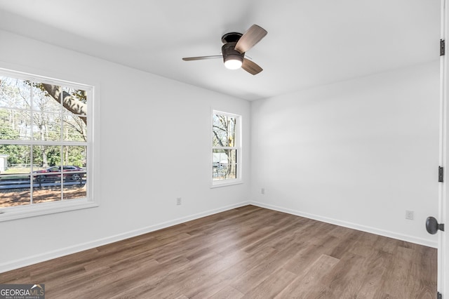 unfurnished room with ceiling fan, baseboards, and wood finished floors