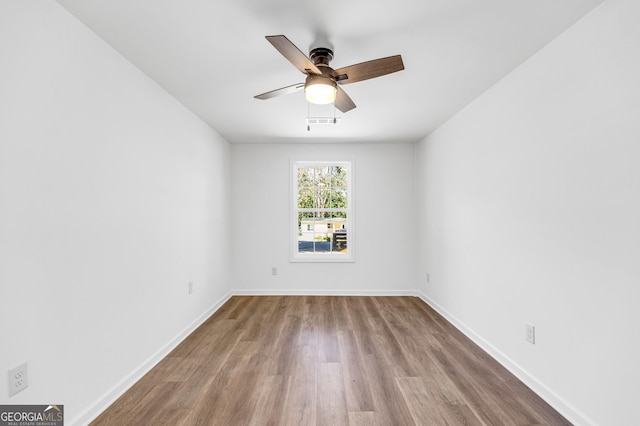 unfurnished room featuring visible vents, baseboards, a ceiling fan, and wood finished floors