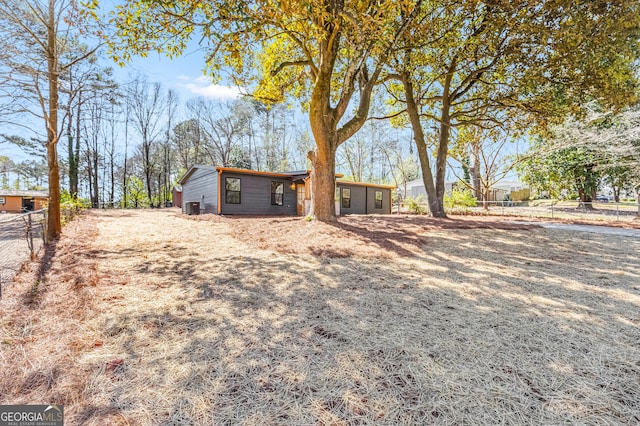 view of yard with central AC and fence