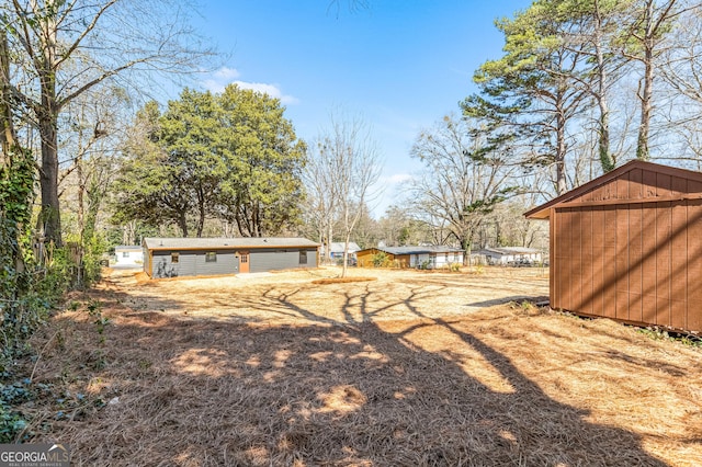 view of yard featuring a storage shed and an outbuilding