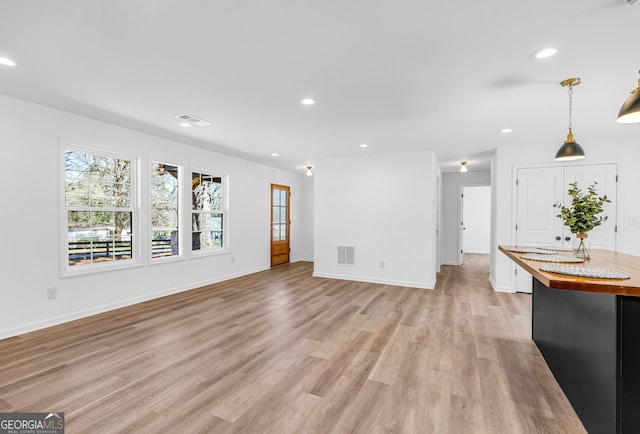 unfurnished living room featuring visible vents, recessed lighting, and light wood-type flooring