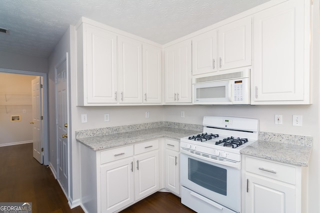 kitchen featuring white cabinets, white appliances, a textured ceiling, and dark wood-type flooring