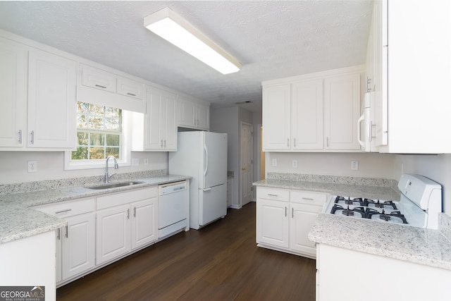 kitchen with a sink, a textured ceiling, dark wood-style floors, white cabinetry, and white appliances