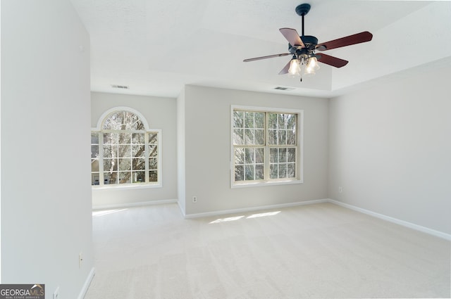 carpeted spare room with visible vents, baseboards, a wealth of natural light, and a textured ceiling