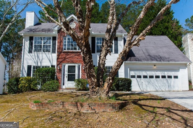 colonial inspired home with brick siding, a chimney, concrete driveway, and an attached garage