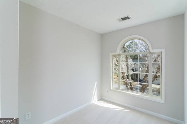 carpeted empty room with visible vents and baseboards