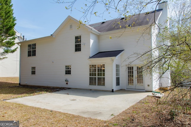 rear view of house featuring french doors, a patio, and a chimney