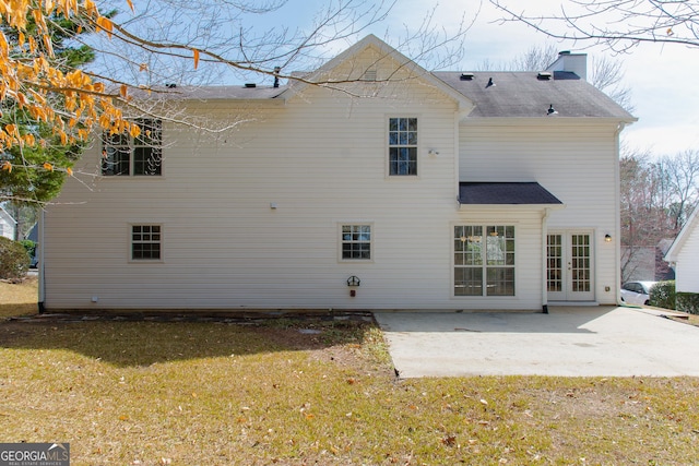 back of house with a patio area, french doors, a chimney, and a yard