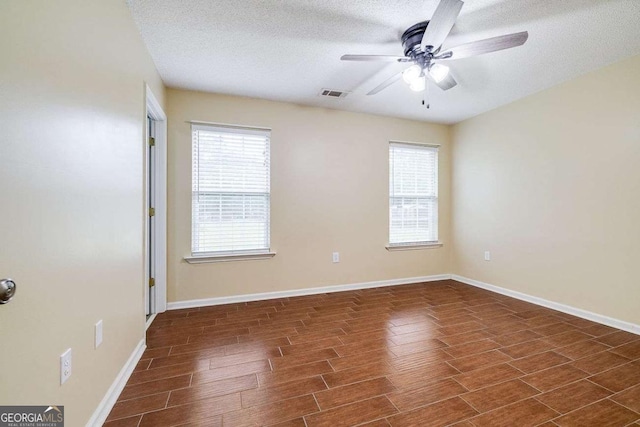 unfurnished room featuring visible vents, a ceiling fan, a textured ceiling, baseboards, and wood tiled floor