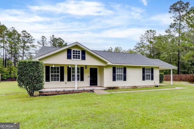 ranch-style house with a front lawn, fence, covered porch, and a shingled roof