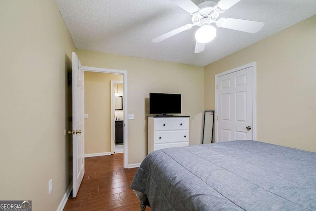 bedroom with ceiling fan, baseboards, a textured ceiling, and dark wood finished floors