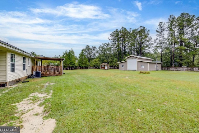 view of yard with central air condition unit, an outdoor structure, a shed, and fence