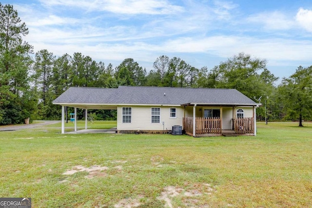 view of front of home featuring cooling unit, an attached carport, and a front lawn