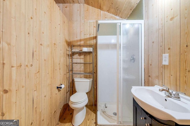 full bath with vanity, wooden walls, a stall shower, vaulted ceiling, and toilet