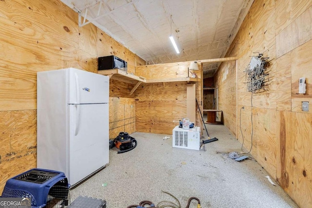 kitchen with black microwave and freestanding refrigerator