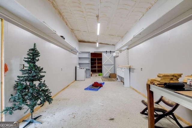 basement with a barn door and baseboards