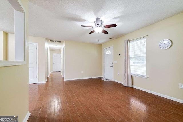 foyer entrance featuring a ceiling fan, wood finished floors, visible vents, and a textured ceiling