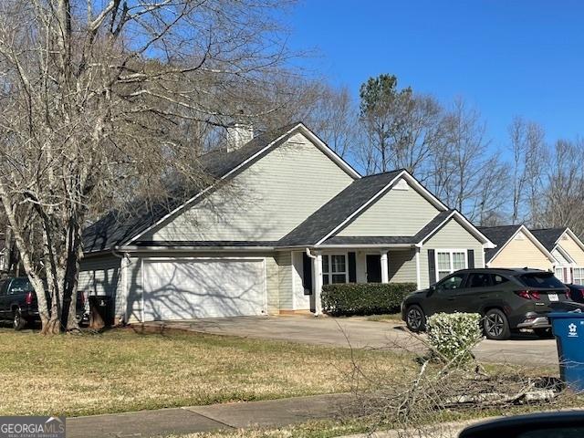 view of front facade featuring a front lawn, concrete driveway, and a garage